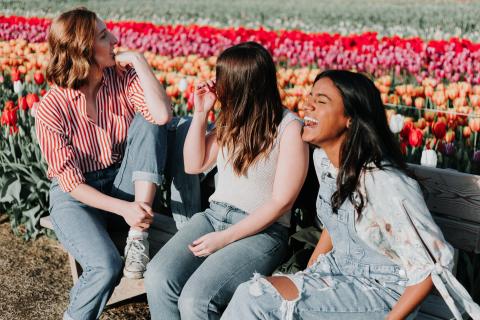 Three women laughing in a park